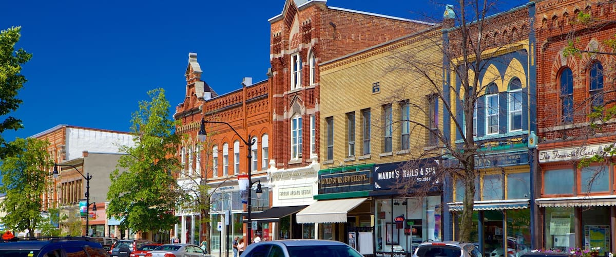 A street lined with historic brick buildings, including a gold star jewelry store and a nail salon.