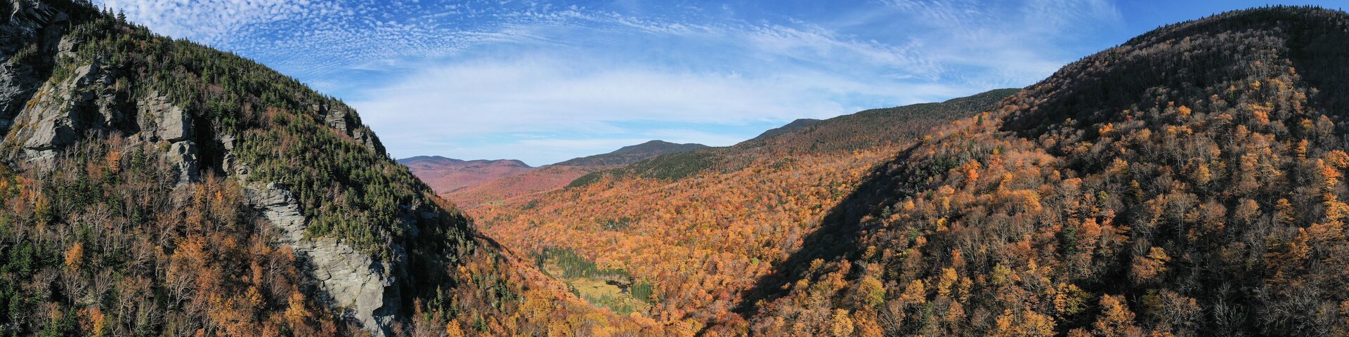 Cañón con follaje otoñal y acantilados rocosos.