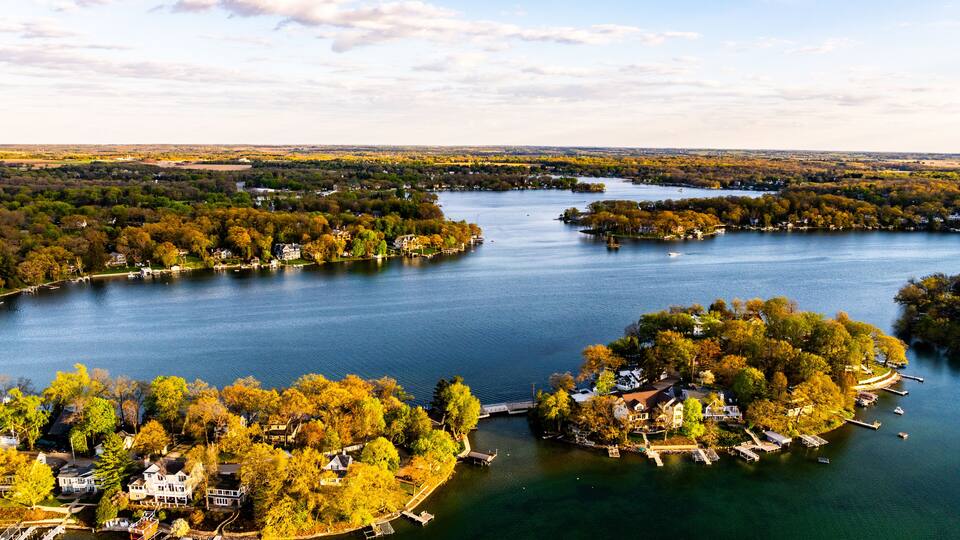 A lake surrounded by trees and houses.