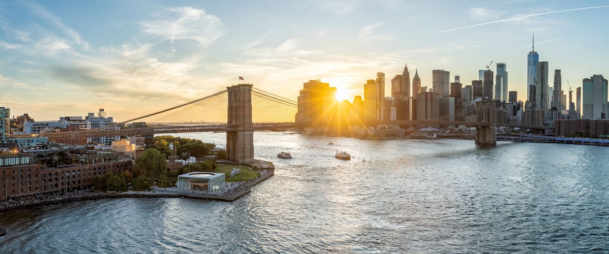New York skyline panorama with Brooklyn Bridge at sunset