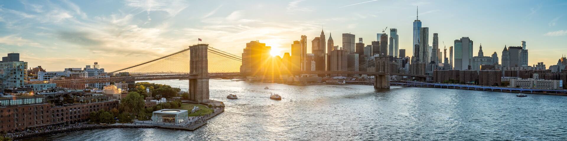 New York skyline panorama with Brooklyn Bridge at sunset