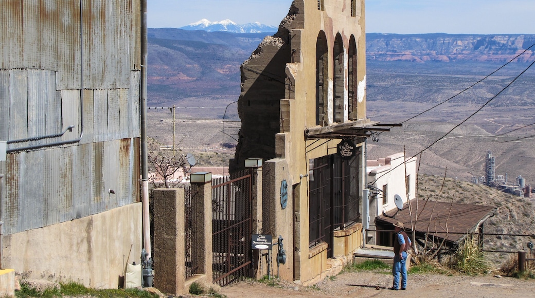 cowboy looking at old jerome facade with San Francisco peaks in the background