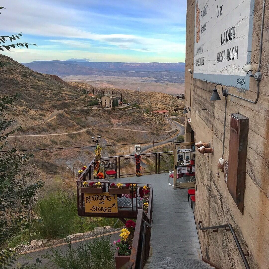 A staircase leading to a building with signs for ladies' restrooms and stores.