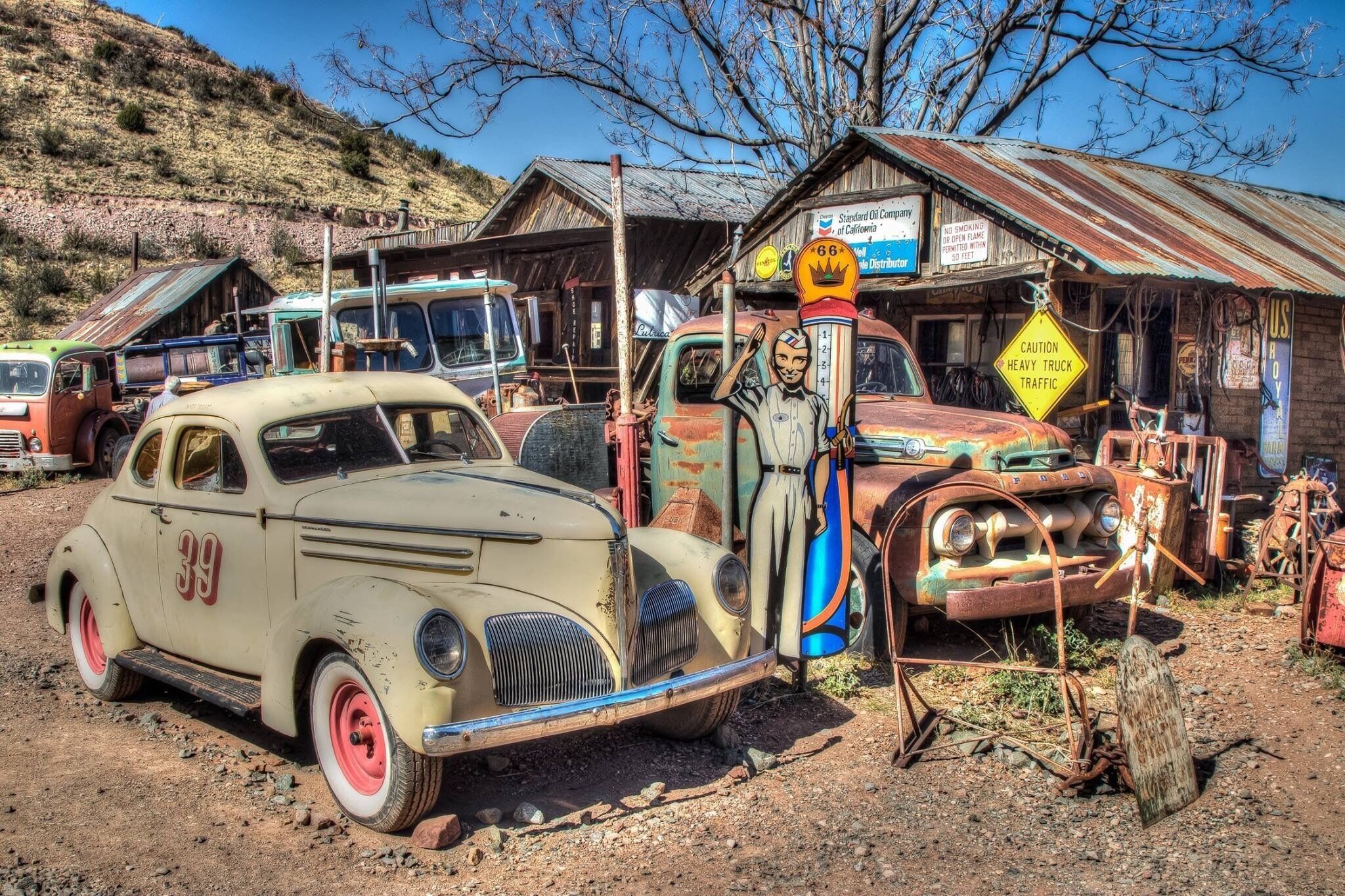 A vintage car with the number 39 parked in a junkyard.
