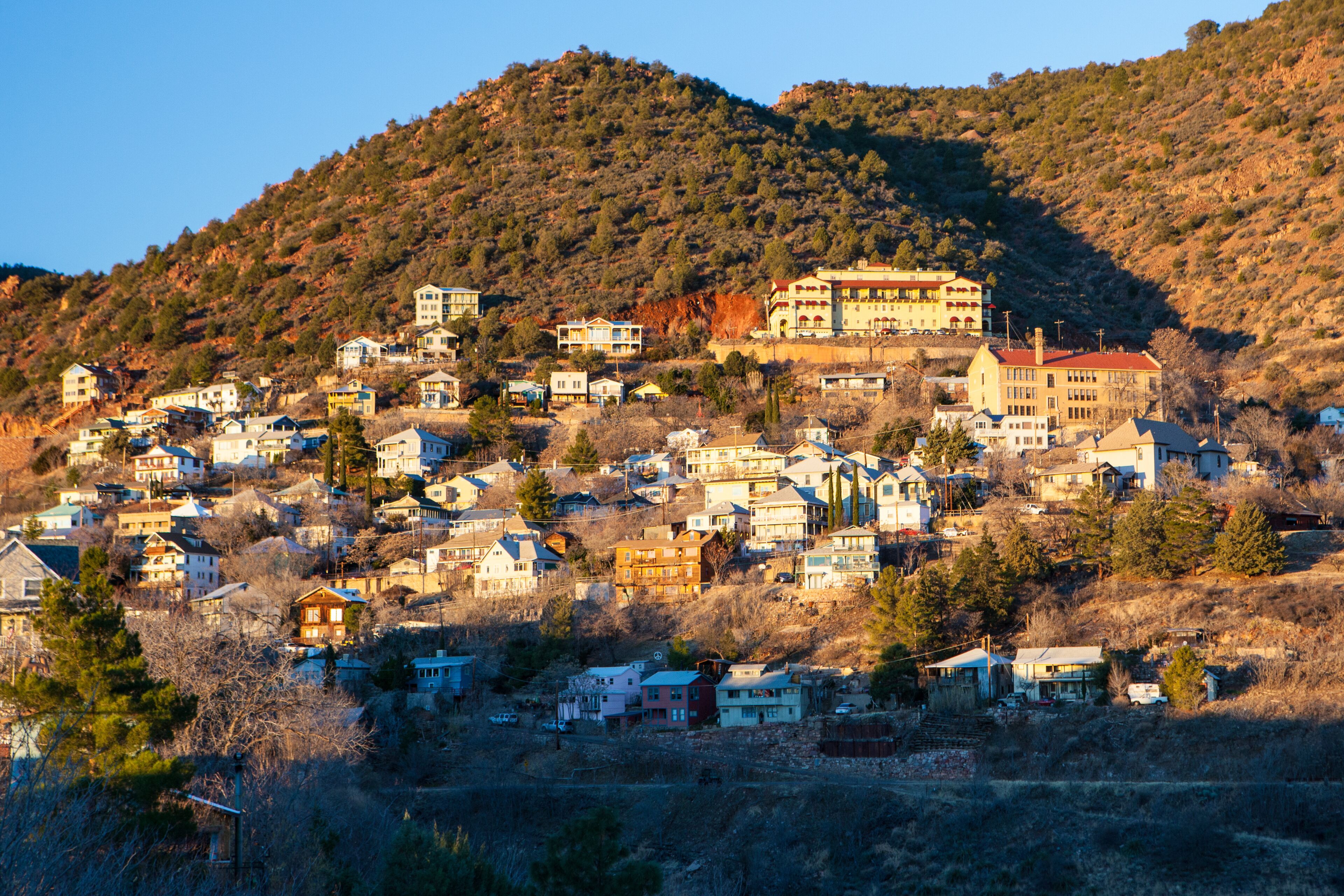 Un pueblo en una ladera con numerosas casas y un edificio destacado en la cima.