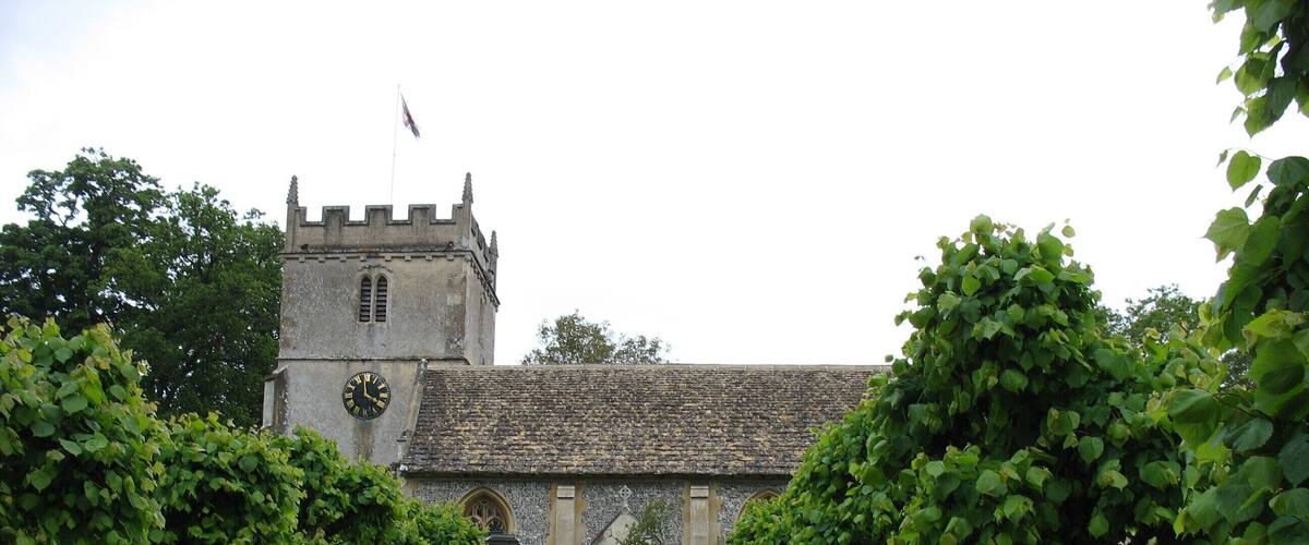 A historic building with a stone facade, a clock, and a flag on top.