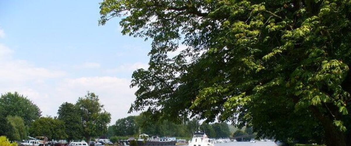 Below Hurley Lock Pleasure cruiser heading downstream, passing a narrowboat moored by the Thames Path.