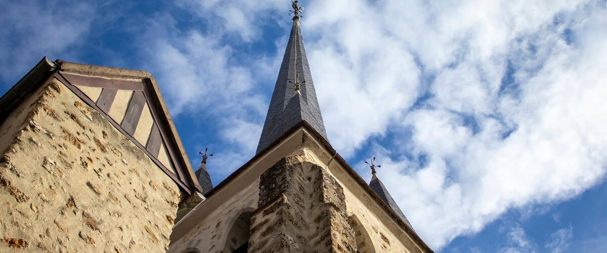 A church with a tall, pointed steeple and arched windows.