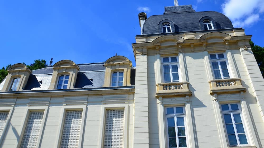 Un bâtiment de style classique, doté d’un toit mansardé et de nombreuses fenêtres.