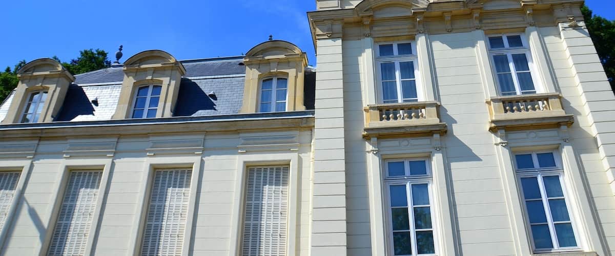 A classical building with a mansard roof and multiple windows.