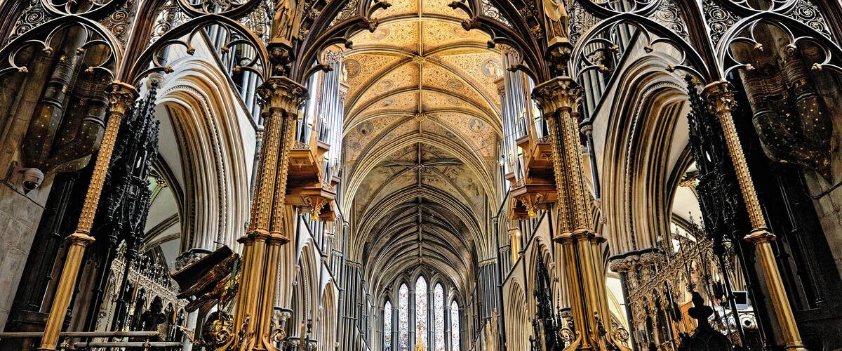 A cathedral interior with Gothic architecture, including pointed arches, ribbed vaults, and ornate columns.