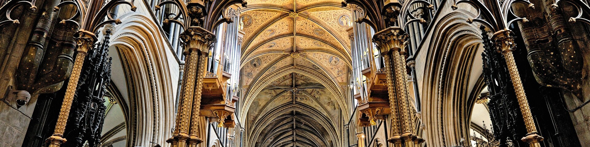 A cathedral interior with Gothic architecture, including pointed arches, ribbed vaults, and ornate columns.