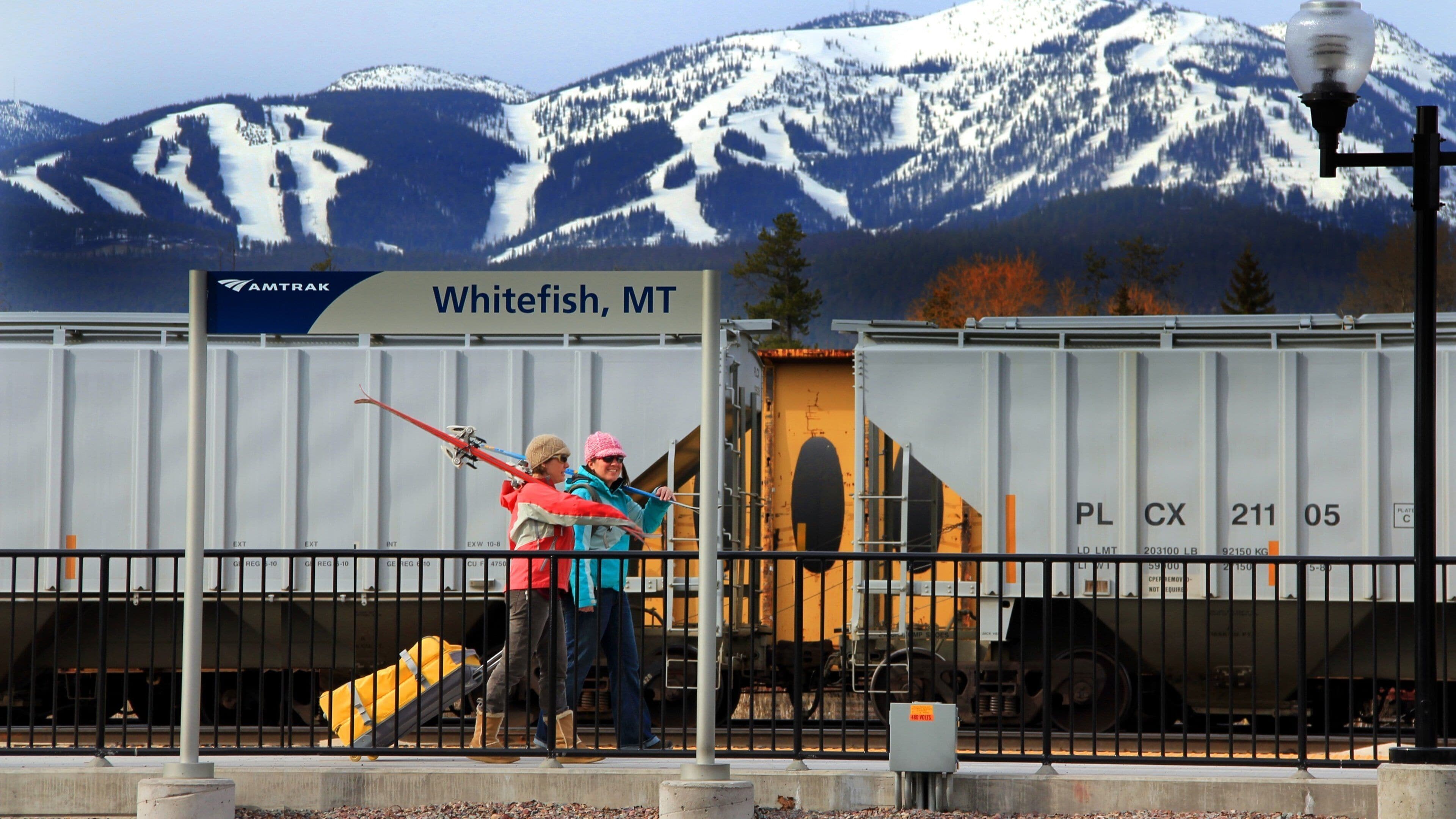 A sign for Whitefish, MT, with a mountainous backdrop.