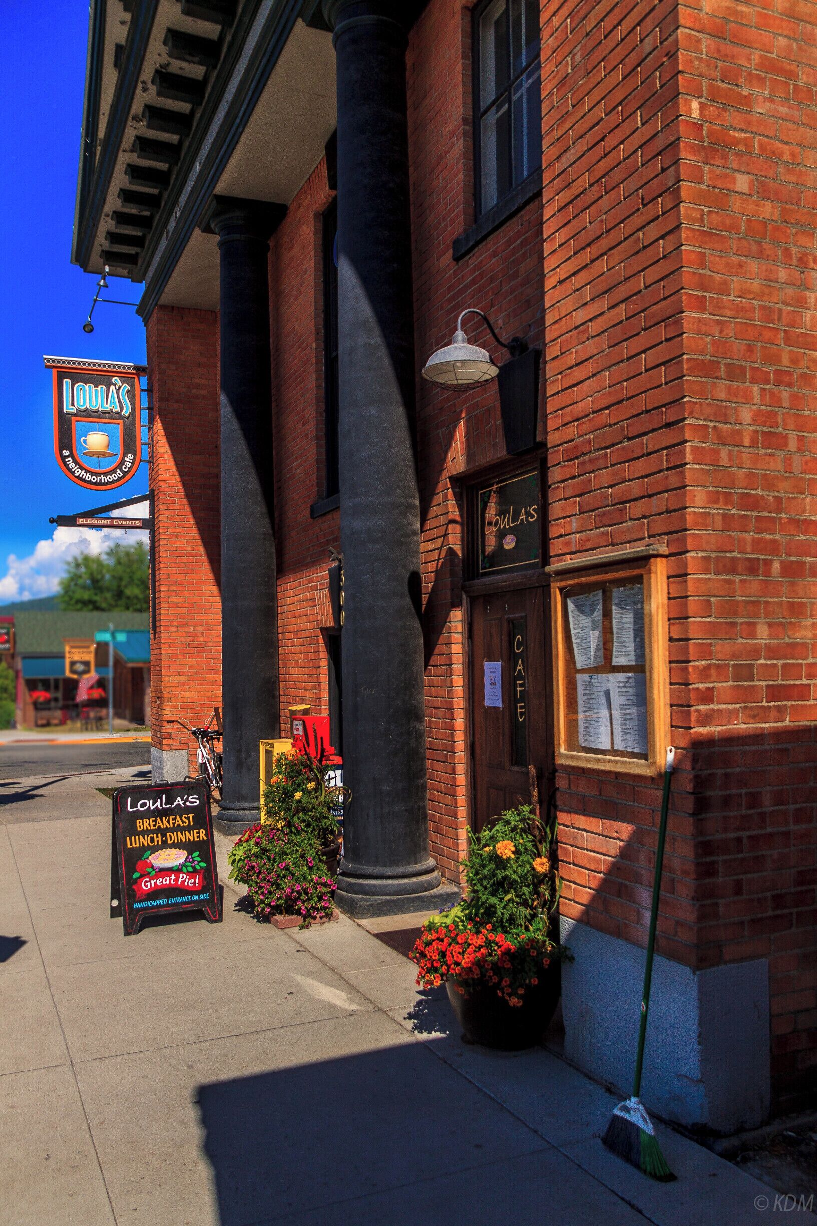 A red brick building with a sign reading "Louisa's" and a signboard advertising breakfast, lunch, and dinner.