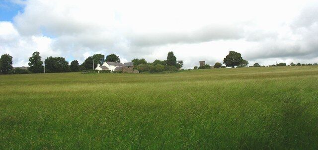 View north across a meadow towards Ty Poeth and Brynsiencyn church