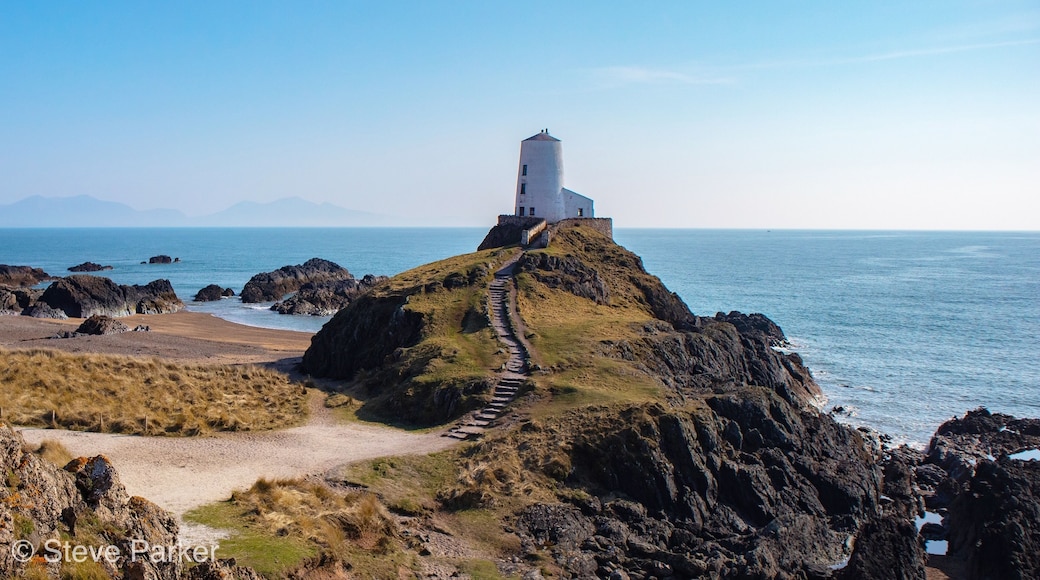 A lighthouse on a rocky cliff overlooking the sea.