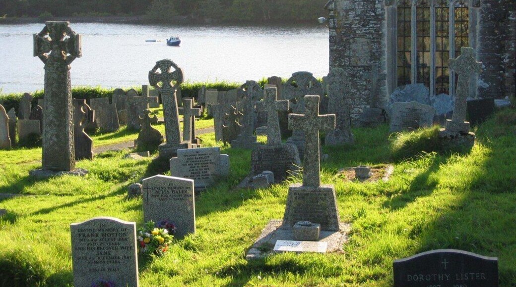 St Winnow parish churchyard, Cornwall, with the east window of the south aisle of the church. Beyond is the Fowey estuary.