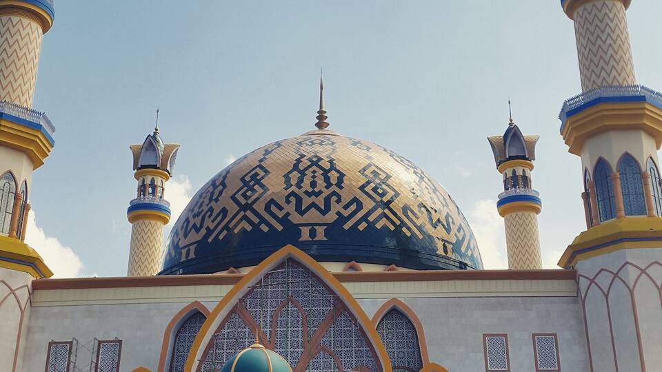 A mosque with a large central dome and four minarets.