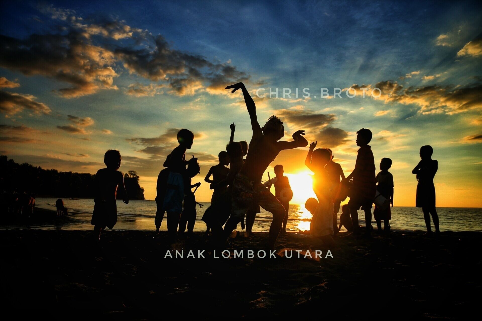 Silhouettes of people at sunset on a beach.