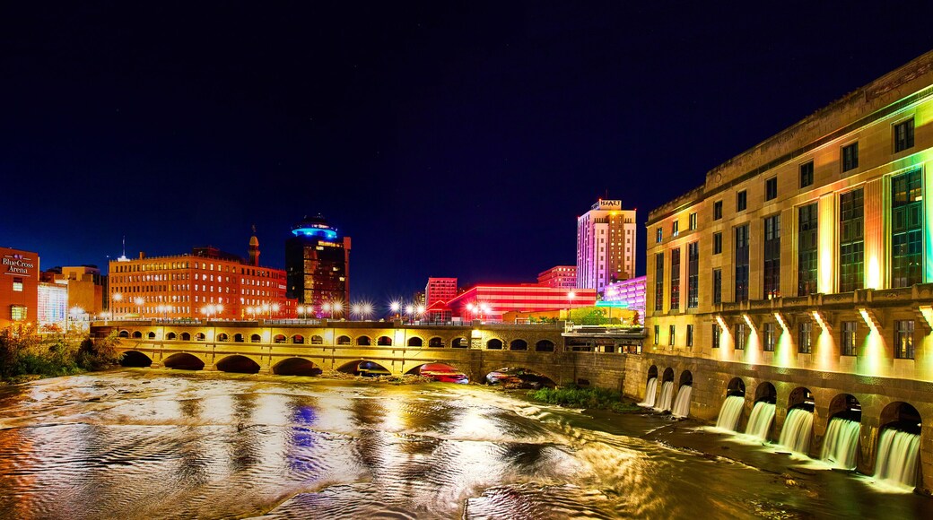 Manmade waterfalls and river in Rochester New York at night with city lights