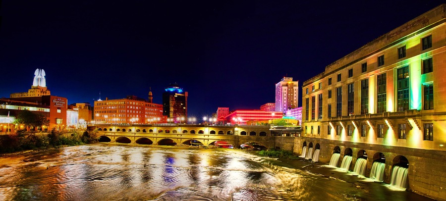 Manmade waterfalls and river in Rochester New York at night with city lights