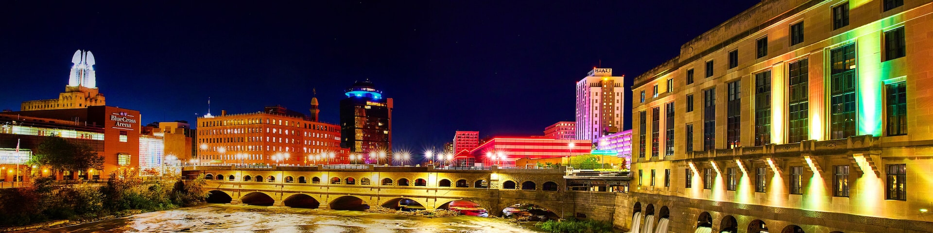 Manmade waterfalls and river in Rochester New York at night with city lights