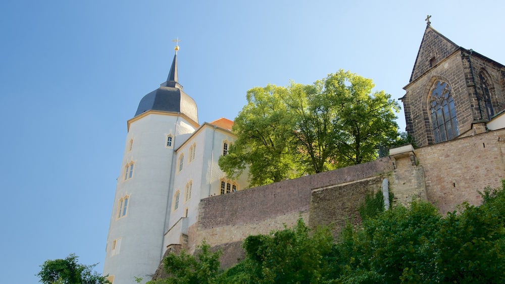 A historic building with a tall tower and a smaller adjacent structure.