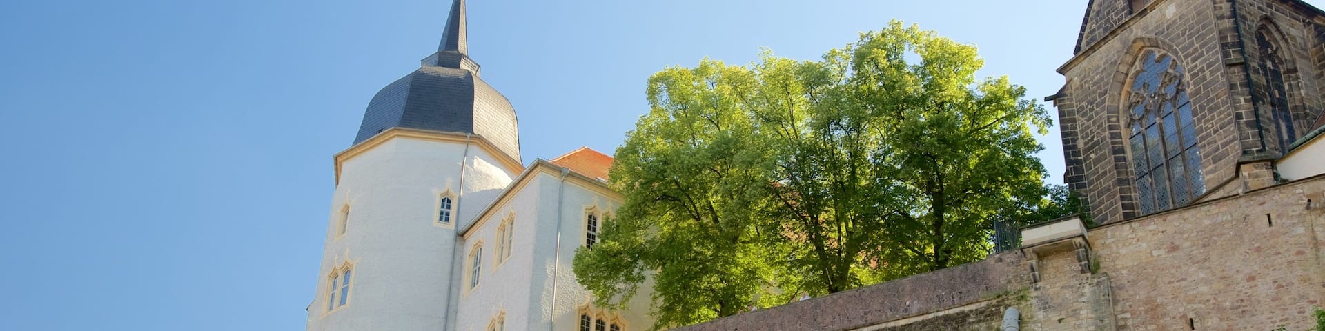 A historic building with a tall tower and a smaller adjacent structure.
