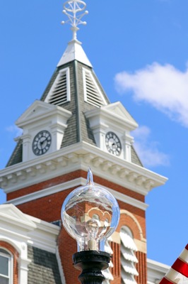 Un farol y una torre del reloj con veleta.