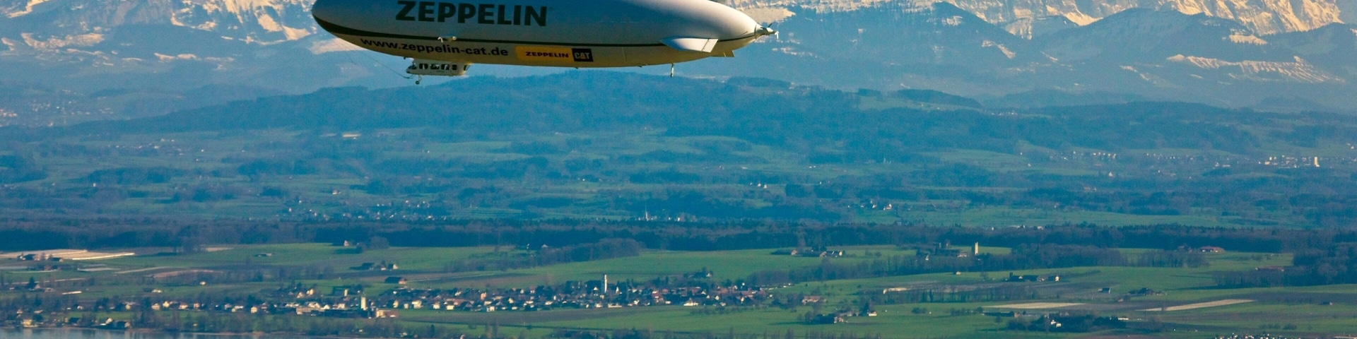 Friedrichshafen showing aircraft, mountains and a lake or waterhole