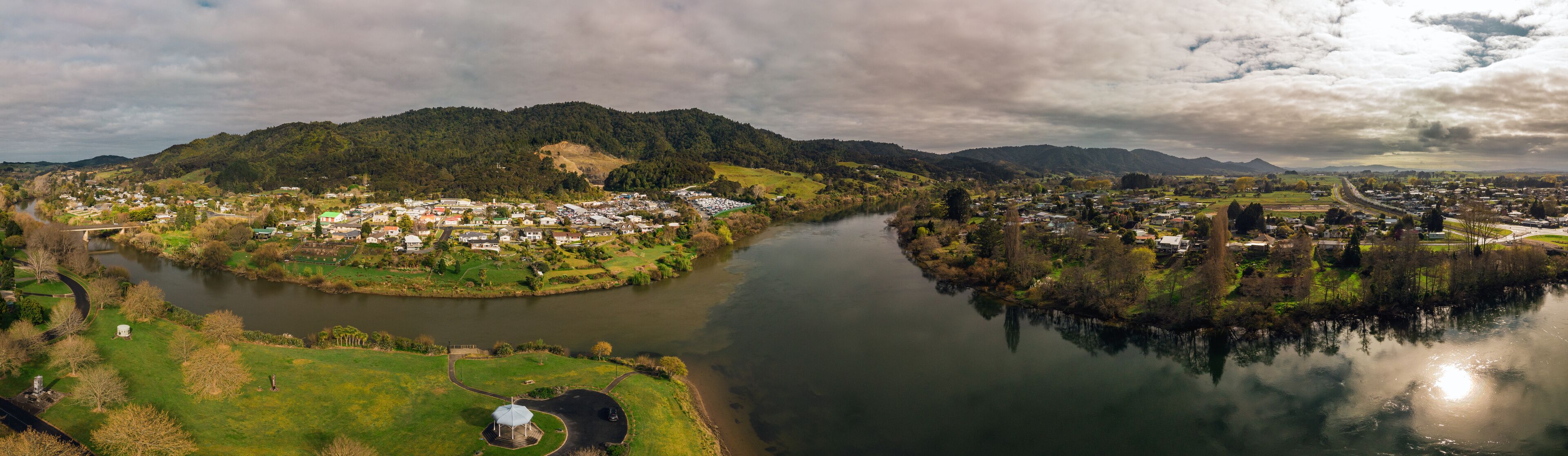 A river winding through a town surrounded by hills.