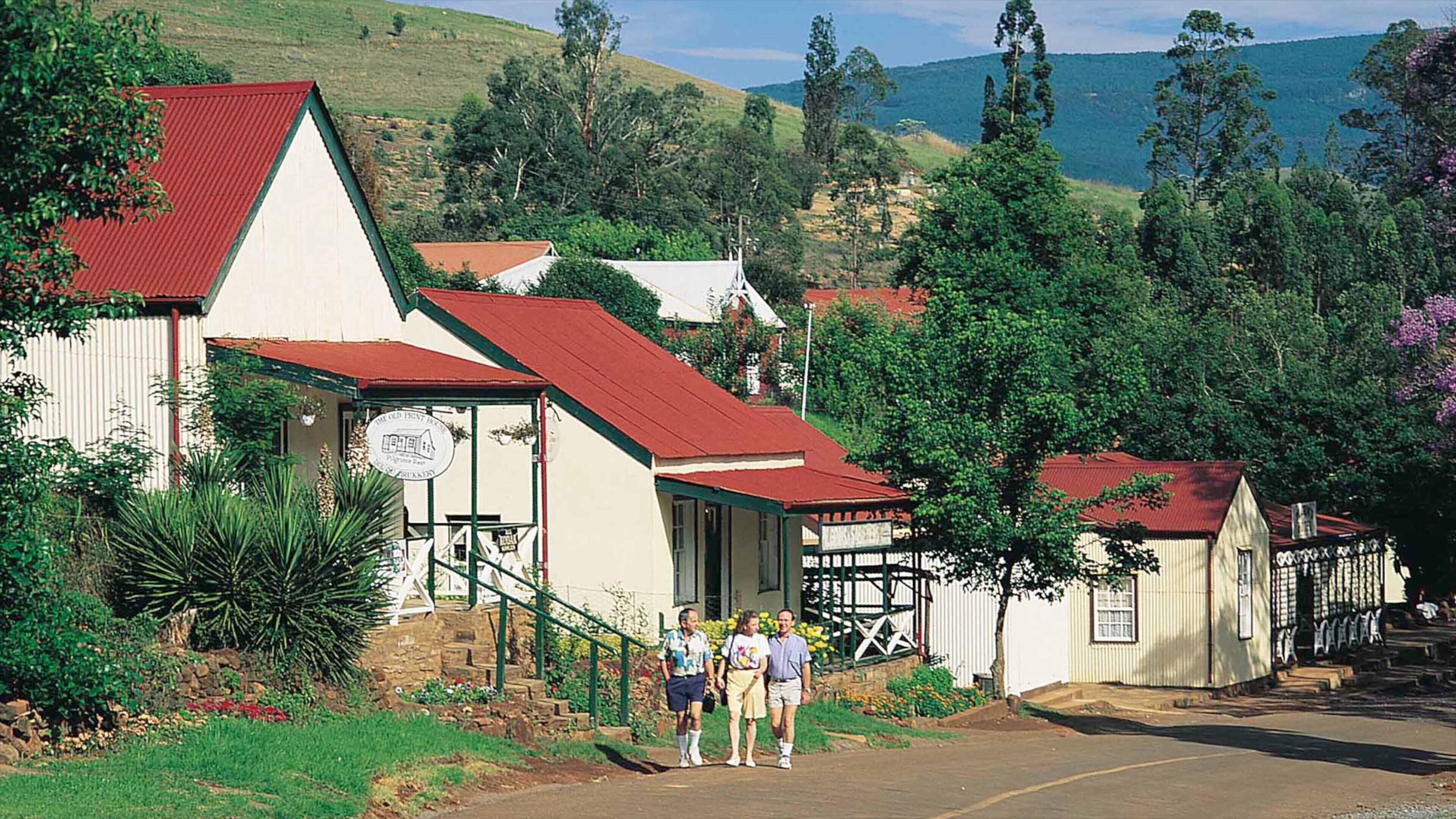 A quaint village with traditional buildings, a stone staircase, and lush greenery.