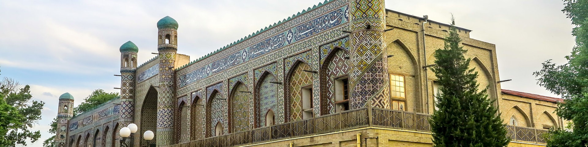 Un edificio histórico con elaborados trabajos en azulejos y dos torres abovedadas.