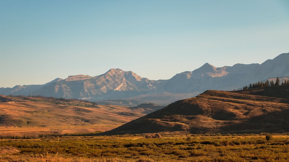 A mountainous landscape with rolling hills and sparse vegetation.