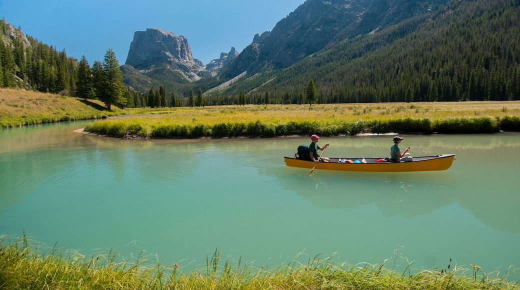 A young couple paddles a canoe on the upper Green River in the Wind River Mountains, Wyoming.