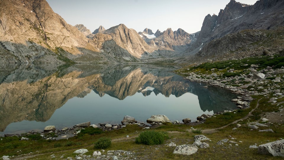 A mountain lake with rocky terrain and a clear reflection.
