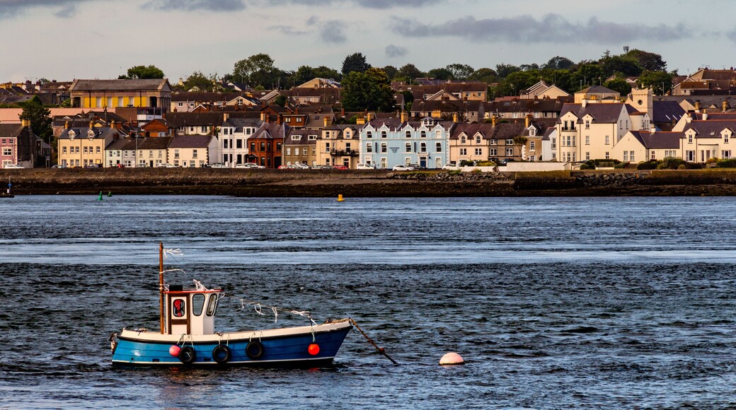 Traditional fishing boat in the harbor of Portaferry. Colorful houses next to the sea on the background. Strangford Lough, Northern Irland, UK