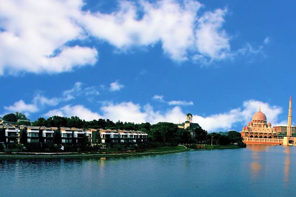 A river with a cityscape, including modern buildings and a prominent domed structure.