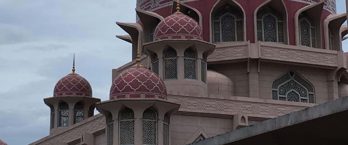 A mosque with large domes and intricate patterns.