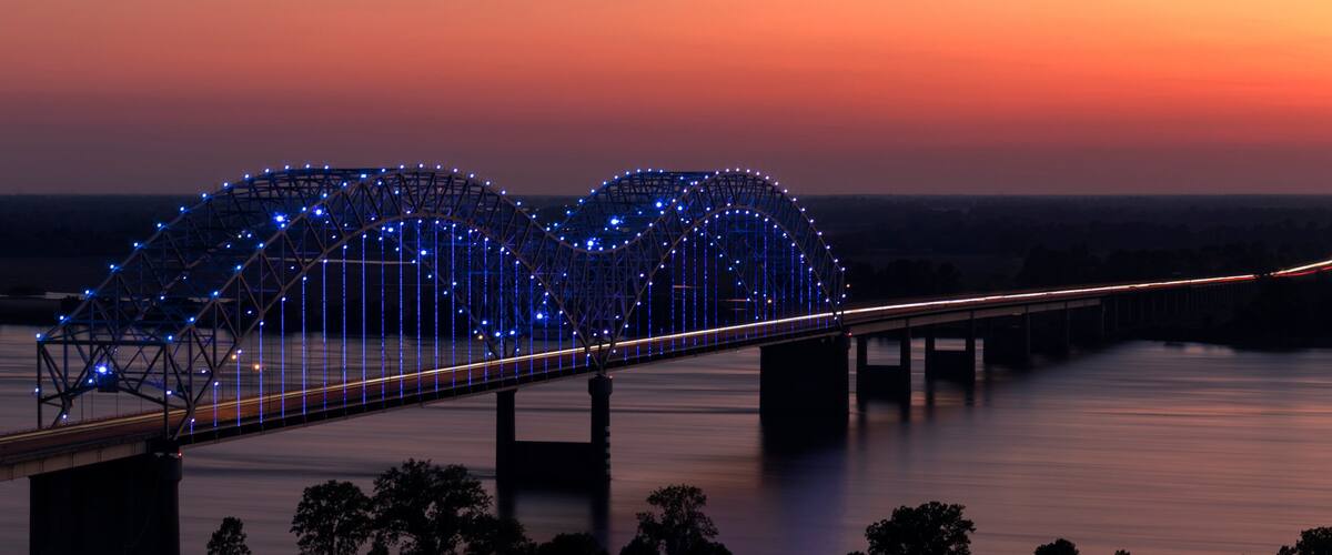 A bridge with blue lights at dusk.