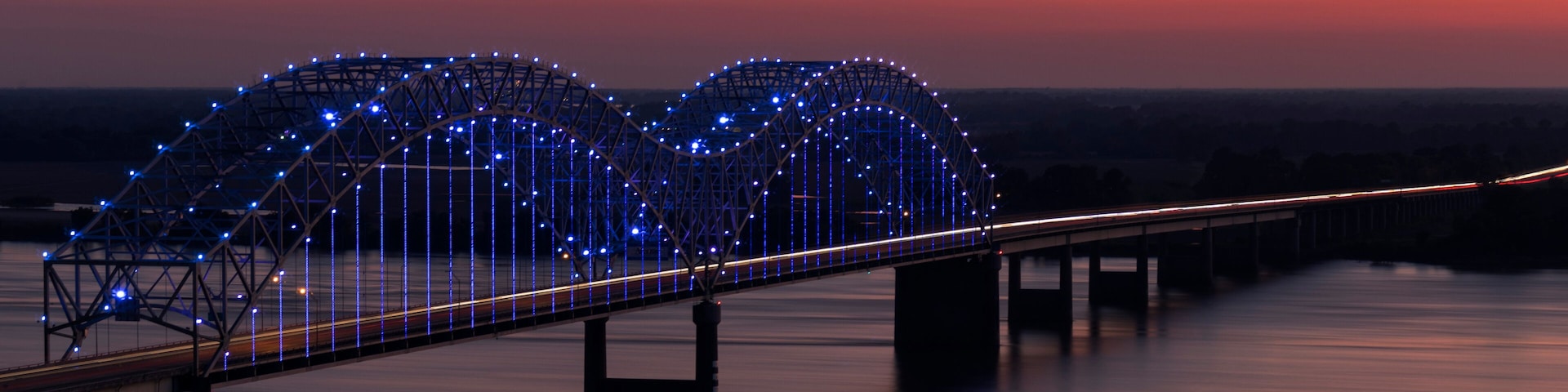 A bridge with blue lights at dusk.