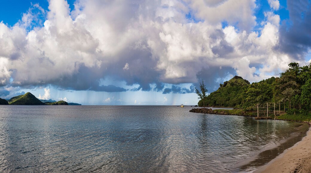 Panoramiс view of Rodney Bay and Gros Islet, Saint Lucia. Expansive waters reflect dramatic clouds over lush green hills and distant landmass.