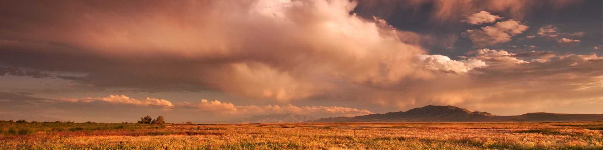 Scenic image of storm clouds at sunset over the wetlands of the Great Salt Lake and Antelope Island State Park, Utah.
