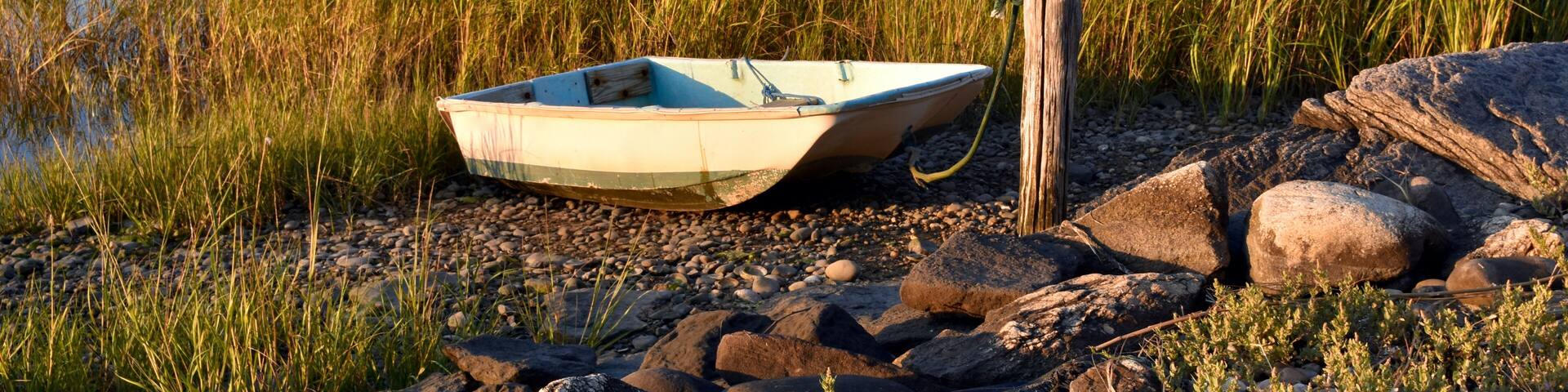 A fisherman's dinghy tied up at the shore in early autumn. Setauket Harbor, Long Island.