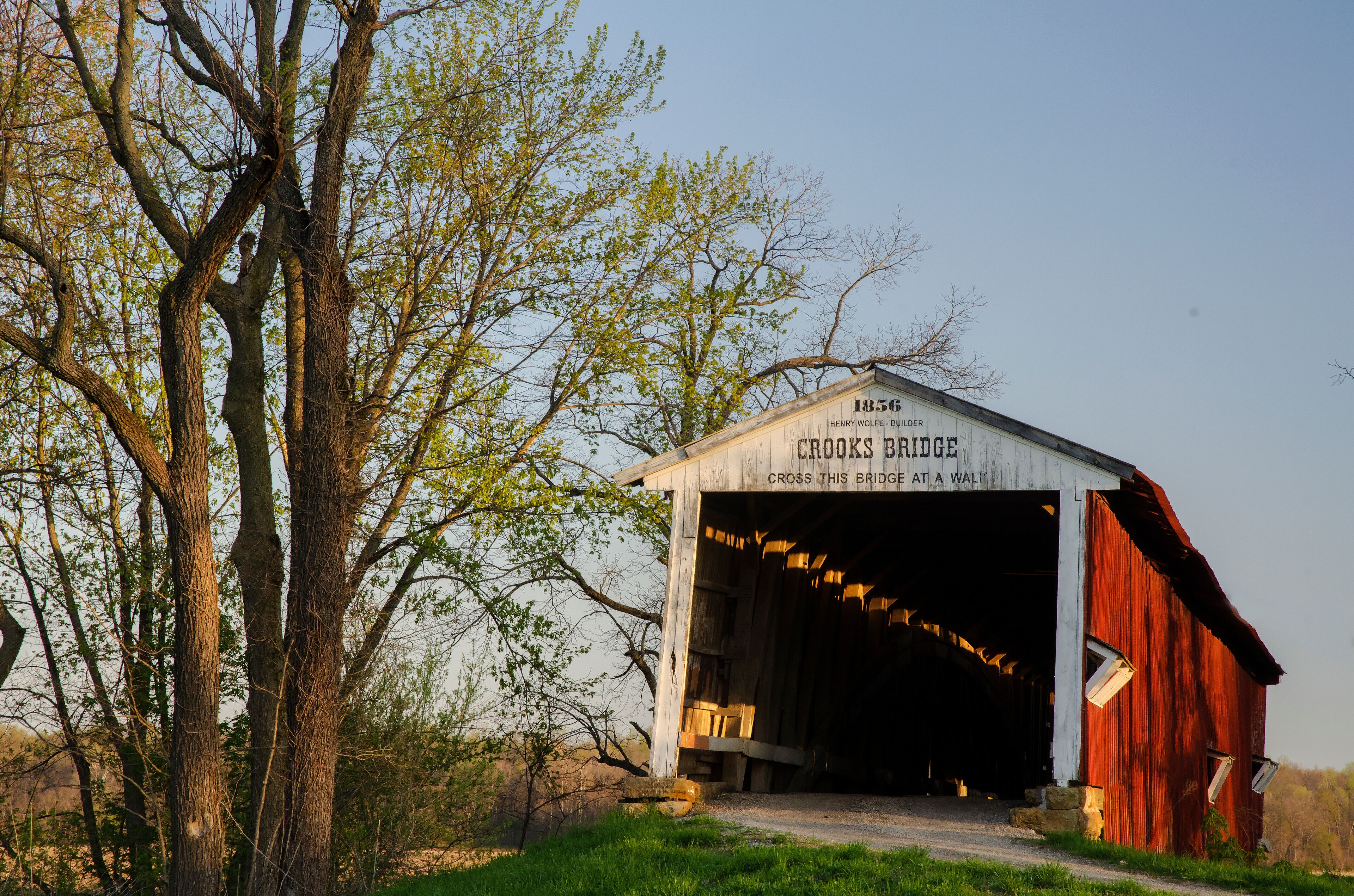 A covered bridge with the inscription "1856 Crooks Bridge" and "Cross this bridge at a wall."
