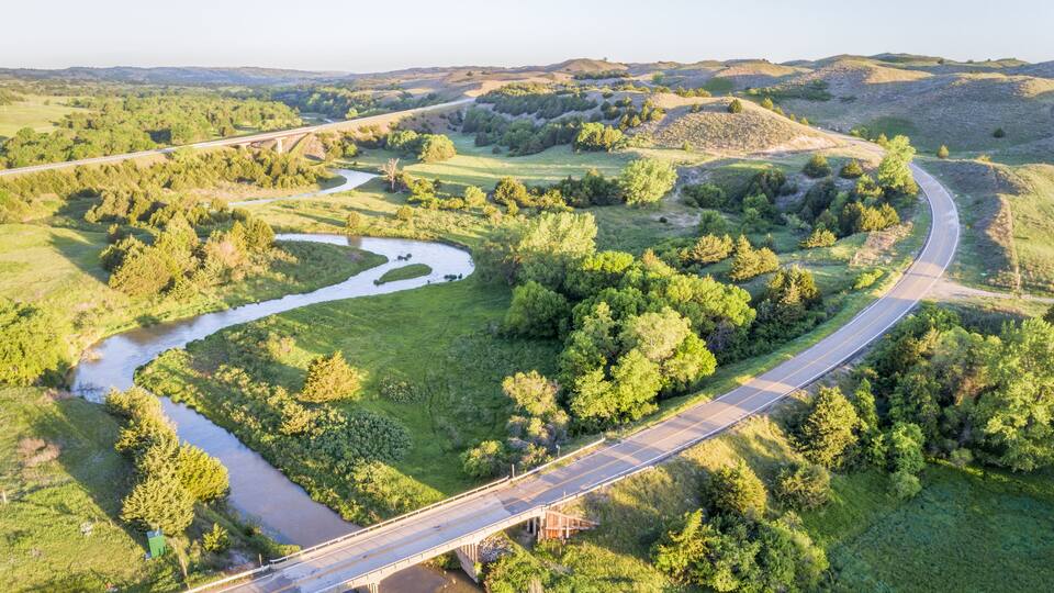 A winding river, a bridge, and rolling hills.