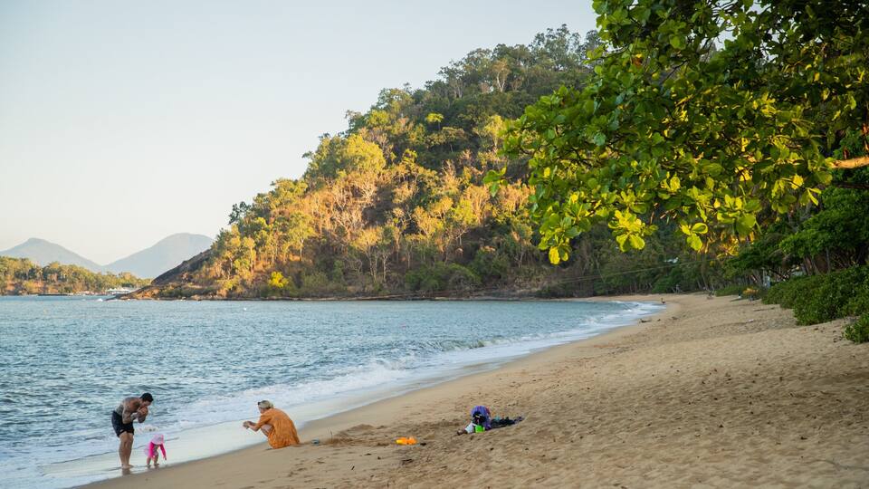 Trinity Beach showing a beach and general coastal views as well as a family