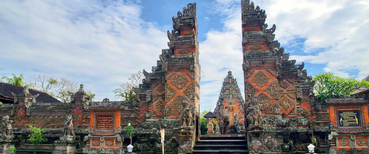 Entrada de um templo com esculturas em pedra elaboradas e uma escadaria que leva a ele.