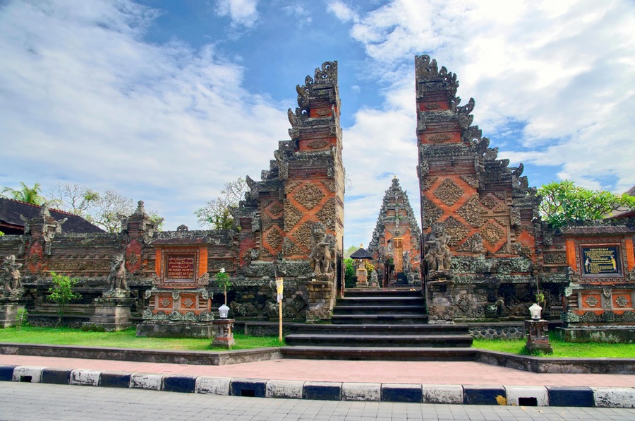 A temple entrance with ornate stone carvings and a staircase leading up to it.