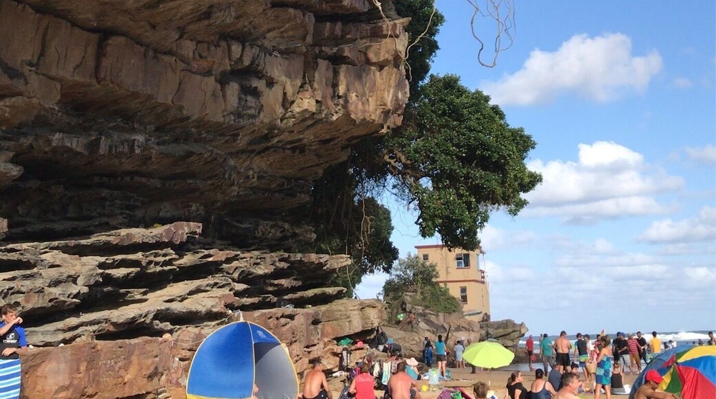 Cliff face of a natural tropical beach cove where sunbathers seek refuge from the hot African sun.